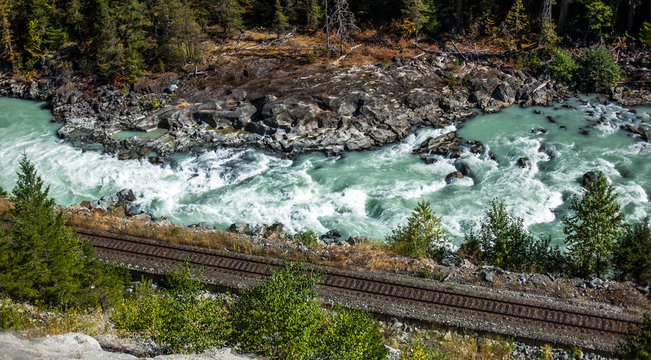 Railway along a rough river.