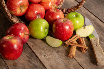Naklejka na ściany i meble Apples red and green on rustic wooden table in basket 