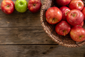 Apples red and green on rustic wooden table in basket 