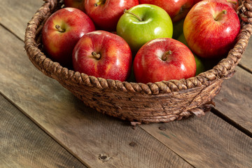 Fototapeta na wymiar Apples red and green on rustic wooden table in basket 