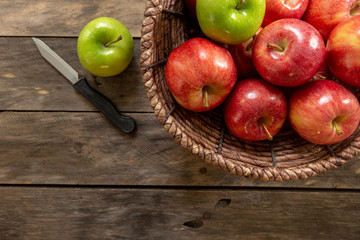 Apples red and green on rustic wooden table in basket 