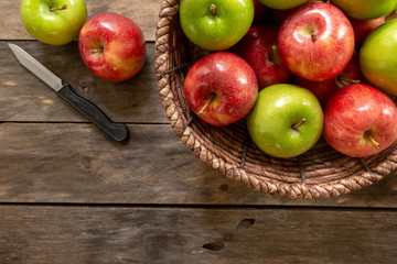 Apples red and green on rustic wooden table in basket 