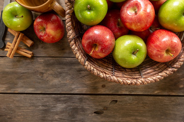 Obraz na płótnie Canvas Apples red and green on rustic wooden table in basket 