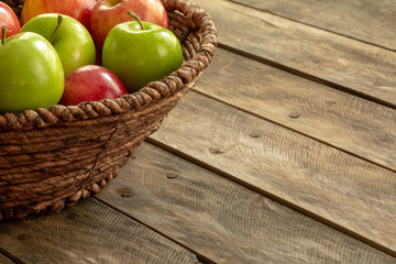 Apples red and green on rustic wooden table in basket 