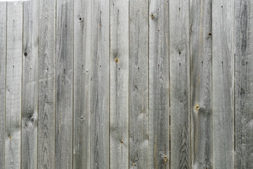 Fence of old unpainted boards background closeup