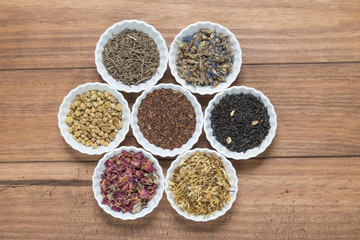 White bowls with different herbs for infusion.