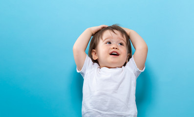 Toddler boy smiling on a bright blue background