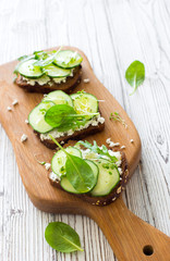 Healthy open sandwichis with fresh vegetables and soft cheese