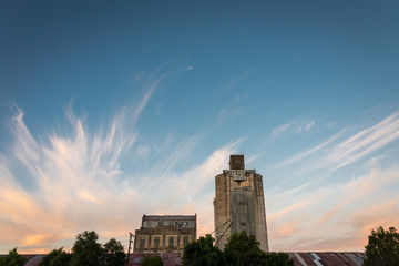 An old grain silo and buildings against a dramatic sunset sky in Nhill, Victoria Australia © Randal