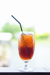 Fresh fruit tea with ice cube in glass on wooden table background.