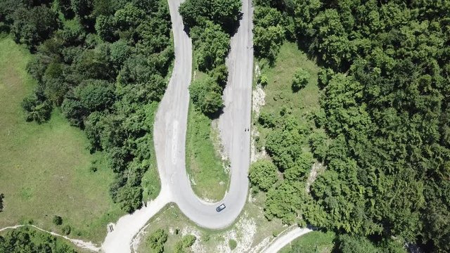 Route to Mandrioli mountain pass in Italy. Vertical view of a bend as an elbow with car and cyclists