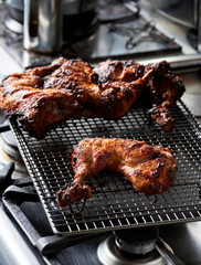 Spiced charcoal grilled chicken legs on a metal rack