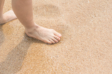 Woman legs walking on the beach sand