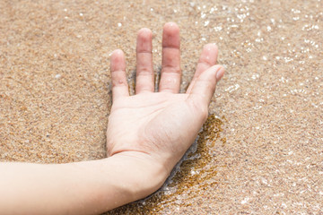 Female hand on the sand at the beach