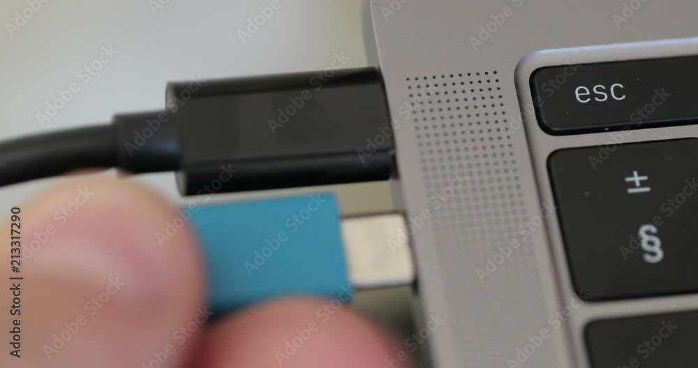 Poster Plugging in a usb type c cable to a laptop computer.