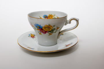 An isolated porcelain cup in a saucer