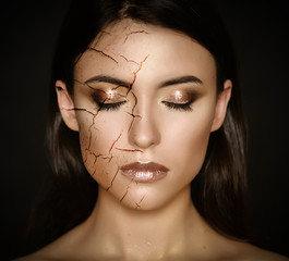 Woman with cracked face as cosmetic and dehydration effect concept.