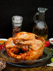 Baked chicken, on an old wooden background. Natural food cooked on the grill.
