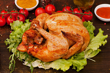 Baked chicken, on an old wooden background. Natural food cooked on the grill.