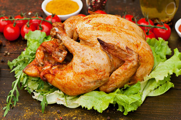 Baked chicken, on an old wooden background. Natural food cooked on the grill.