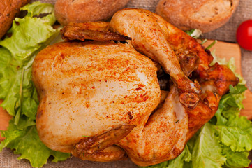 Baked chicken, on an old wooden background. Natural food cooked on the grill.