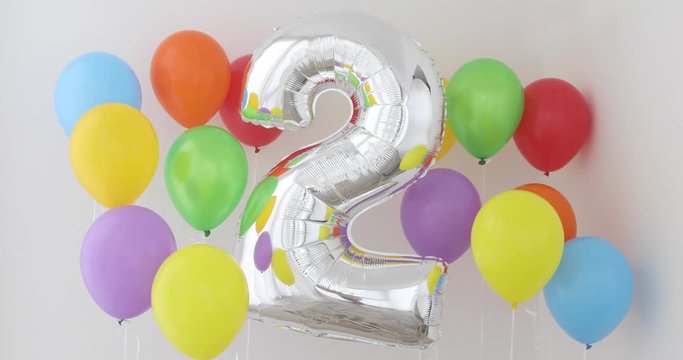 Number 2 (two) of color balloon on a light background. Birthday balloon for baby with , rainbow color- red, orange, yellow, green, sky blue and fiolet balloons