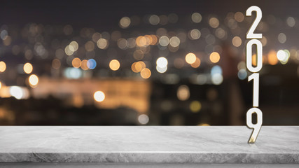 Gold metal letter of "2019" on Empty white marble stone table with blurred bokeh light background,Template mock up for adding your design.
