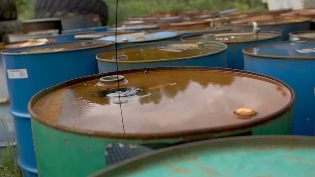 The oil is pouring on ld dirty barrels