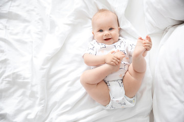 Cute little baby lying on bed, top view