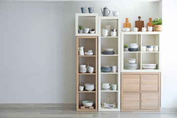 Kitchen shelving with dishes on white wall background
