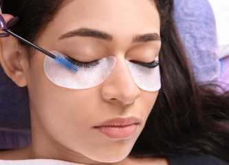 Fototapeta premium Young woman undergoing eyelash extensions procedure, closeup