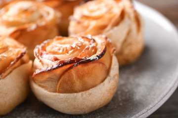 Apple roses from puff pastry on plate, closeup