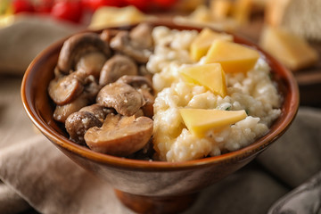 Bowl with risotto and mushrooms on table, closeup