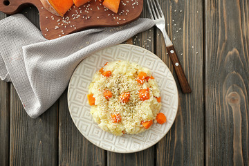 Plate with delicious pumpkin risotto on wooden table
