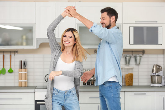 Happy couple dancing in kitchen