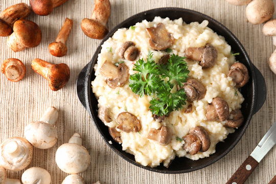 Composition with risotto and mushrooms on table, top view