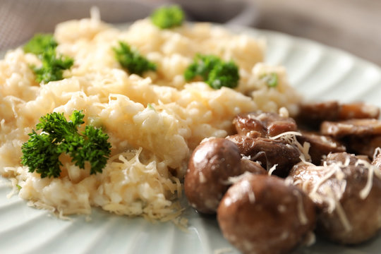 Tasty risotto with mushrooms on plate, closeup