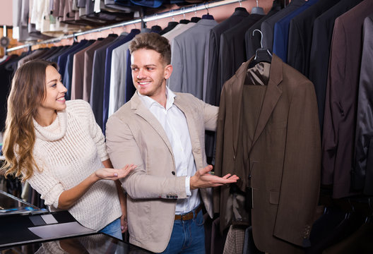 couple choosing new suit in men’s cloths store