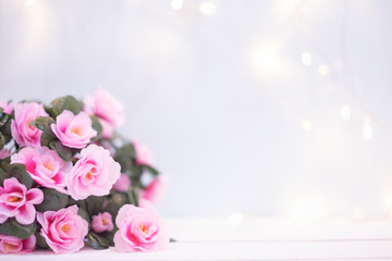 Sweet soft pastel pink korea style flower on white wooden table decoration spakling light wall for valentine or anniversary important day with copy space.