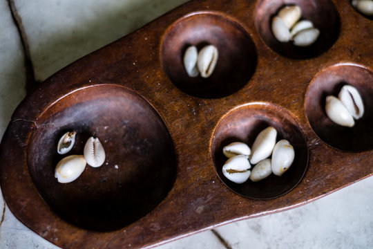 Closeup of a Sungka played with sea shells, which comes from a family line of board games called Mancala in the Asian countries. Selective focus. 