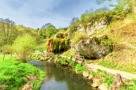 Natural monument Dreim&uuml;hlen waterfall in German Eifel overgrown with mosses in wooded area falling in river