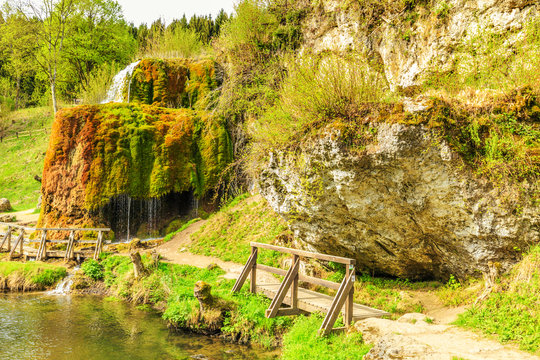 Natural monument Dreim&uuml;hlen waterfall in German Eifel overgrown with mosses in wooded area falling in river