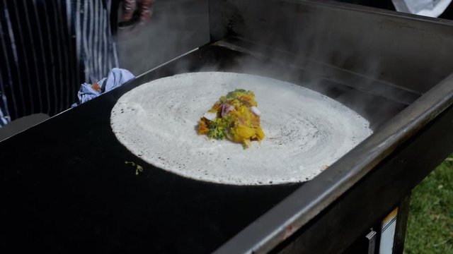 Chef from Rishis Glasgow placing potato filling on dosa