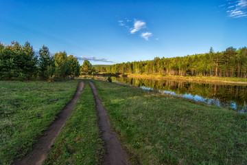 Fototapeta na wymiar Road going near a forest lake in Siberia