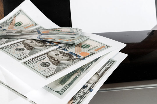 Printer and printed US dollars, counterfeit banknotes, currency counterfeiting. Counterfeiters, printing press, inflation.