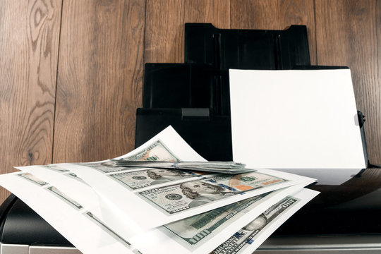 Printer and printed US dollars, counterfeit banknotes, currency counterfeiting. Counterfeiters, printing press, inflation.