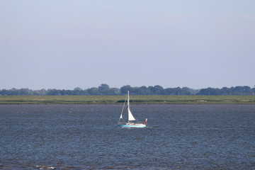 Sailboat or yacht on a lake in nice weather and blue sky