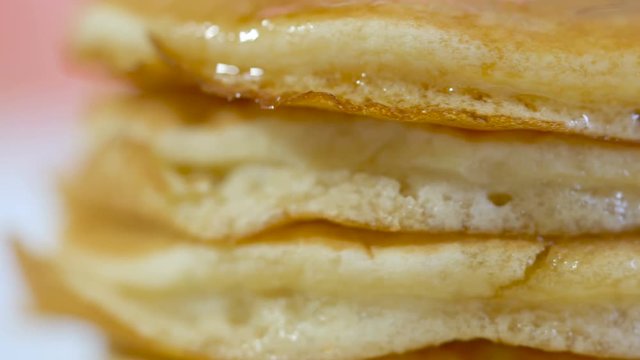 Stack of pancakes drizzled with syrup, macro closeup.