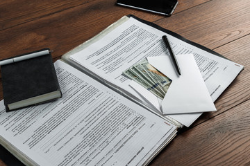 Obraz premium money in the envelope lie on the workplace in the office. View from above. The bribe offered in the file. The concept of bribery and corruption.