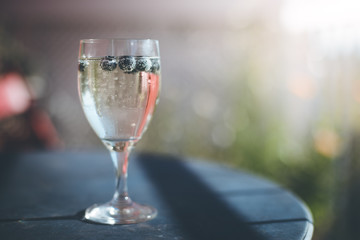 Sektglas mit Heidelbeeren auf Balkon, Urlaub